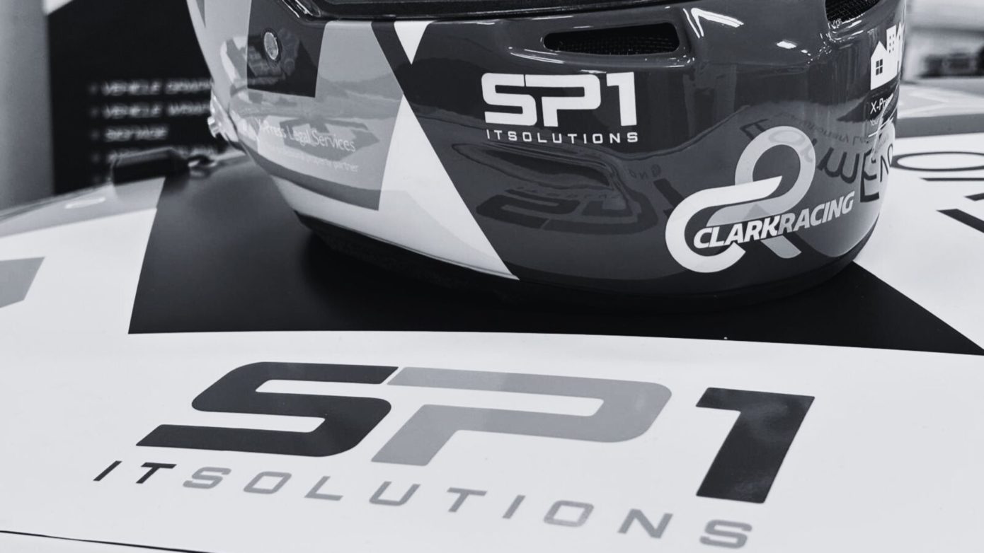 Close-up of Simon Clark’s racing helmet and SP1 IT Solutions branding on a Porsche 911 at the 2025 Porsche Club Championship
